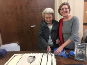 Two women cutting cake